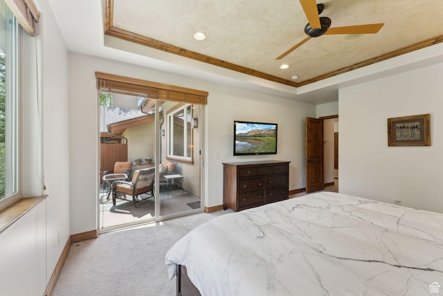 carpeted bedroom with a tray ceiling, access to exterior, baseboards, ornamental molding, and recessed lighting