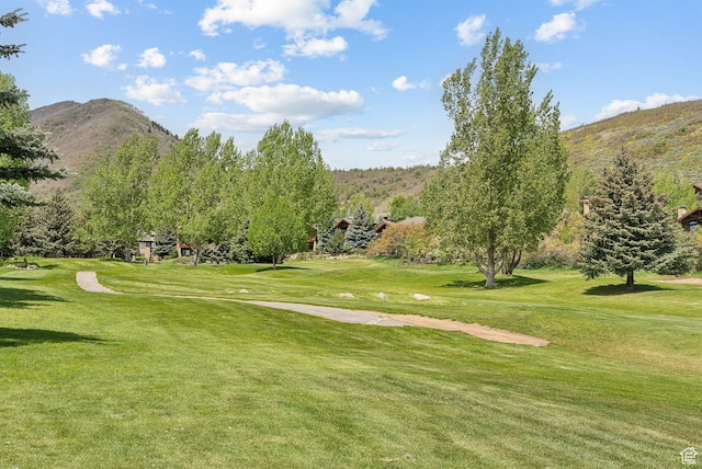 surrounding community with a mountain view, golf course view, and a yard
