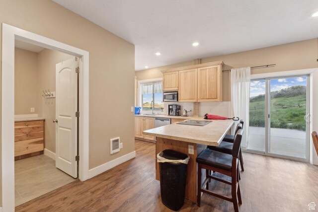 8819 Highfield Rd Unit 61, Park City, UT 84098 - kitchen featuring light brown cabinets, appliances with stainless steel finishes, light countertops, a breakfast bar, and light wood-type flooring