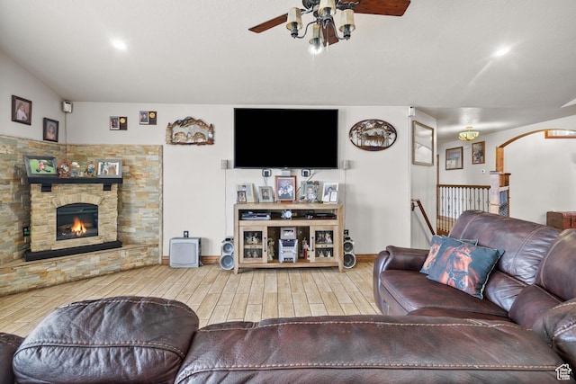 2521 W Ridgeline Rd, Stockton, UT 84071 - living room with a ceiling fan, wood finished floors, a stone fireplace, baseboards, and arched walkways