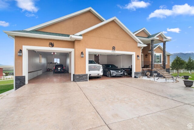 2521 W Ridgeline Rd, Stockton, UT 84071 - view of front of house with an attached garage, concrete driveway, stucco siding, and stone siding