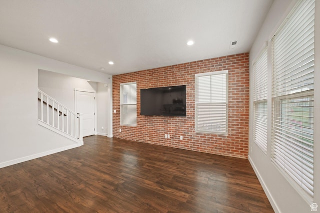 11413 S Kitty Hawk Rd W, South Jordan, UT 84009 - unfurnished living room featuring brick wall, dark wood-style flooring, stairs, baseboards, and recessed lighting