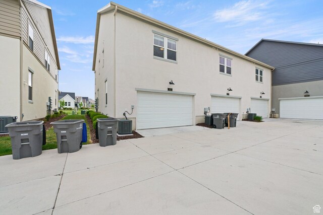 11413 S Kitty Hawk Rd W, South Jordan, UT 84009 - back of house with stucco siding, driveway, an attached garage, and cooling unit