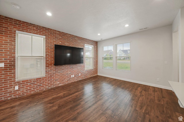 11413 S Kitty Hawk Rd W, South Jordan, UT 84009 - unfurnished living room with wood finished floors, brick wall, baseboards, a textured ceiling, and recessed lighting