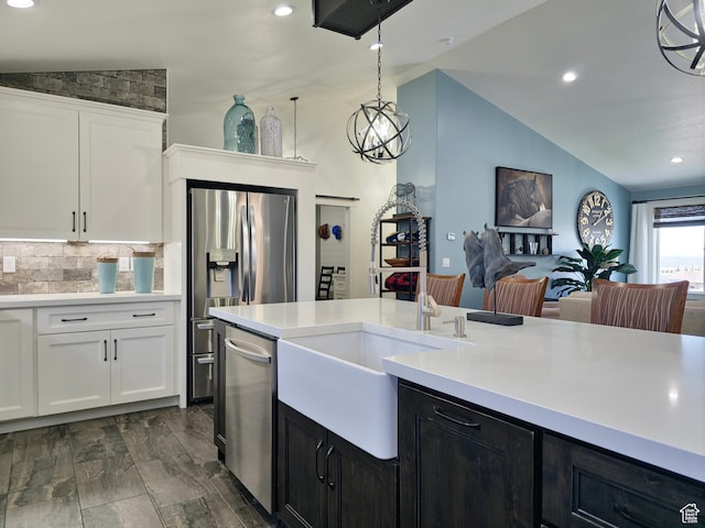 123 Red Hawk Ave, Evanston, WY 82930 - kitchen with vaulted ceiling, stainless steel appliances, a sink, light countertops, and white cabinets