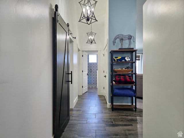 123 Red Hawk Ave, Evanston, WY 82930 - corridor with a barn door, a chandelier, dark wood finished floors, baseboards, and a towering ceiling