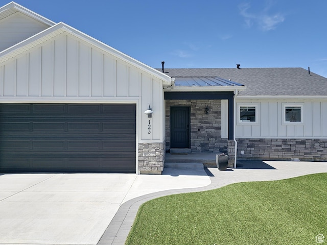123 Red Hawk Ave, Evanston, WY 82930 - view of front of house featuring stone siding, a garage, board and batten siding, driveway, and a shingled roof