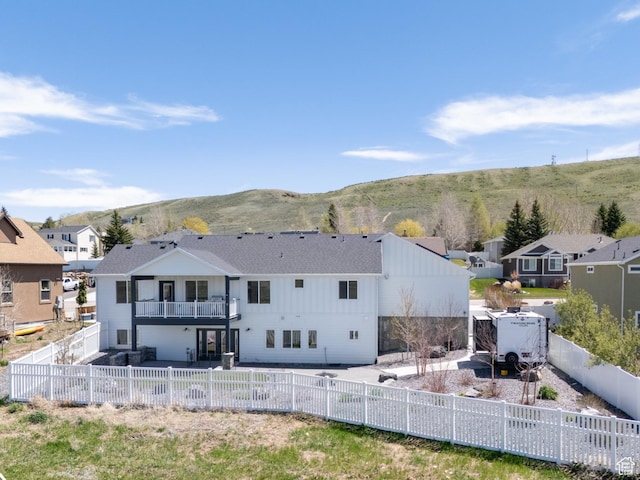 123 Red Hawk Ave, Evanston, WY 82930 - rear view of property with a patio, a balcony, a fenced backyard, a residential view, and a mountain view