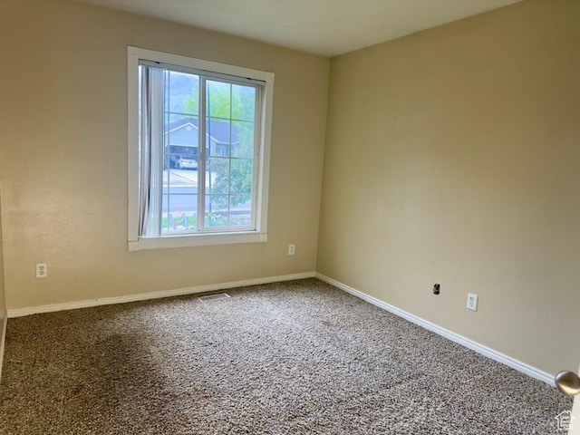 unfurnished room featuring plenty of natural light and carpet floors