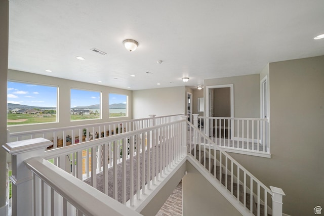 corridor featuring recessed lighting and an upstairs landing