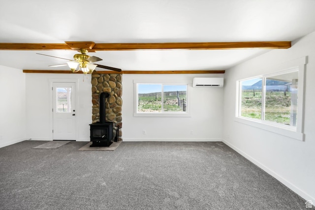 1665 S Kennedy Dr, Marysvale, UT 84750 - unfurnished living room featuring beam ceiling, a wall unit AC, a wood stove, carpet floors, and baseboards