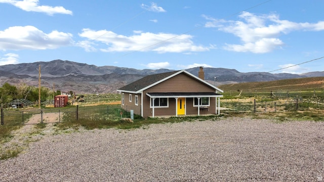 1665 S Kennedy Dr, Marysvale, UT 84750 - view of front of property featuring a mountain view, fence, covered porch, and a chimney