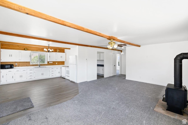 1665 S Kennedy Dr, Marysvale, UT 84750 - unfurnished living room featuring a chandelier, a wood stove, baseboards, a ceiling fan, and a sink