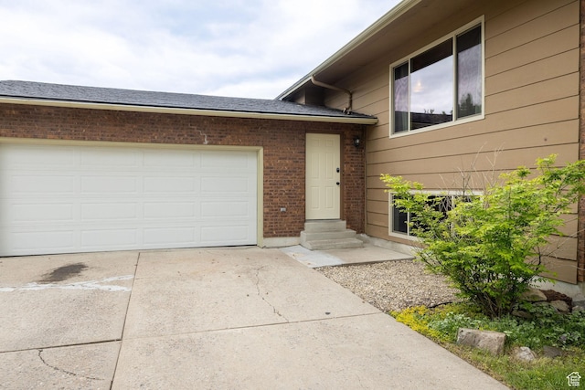 910 W 370 S, Logan, UT 84321 - doorway to property with concrete driveway, brick siding, and a garage