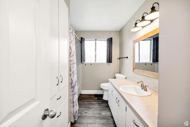 910 W 370 S, Logan, UT 84321 - bathroom with wood finished floors, vanity, toilet, baseboards, and a shower with curtain