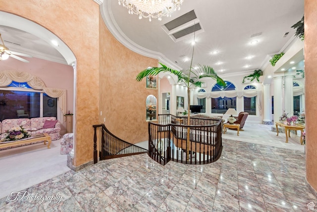 dining space featuring arched walkways, crown molding, a ceiling fan, a chandelier, and baseboards