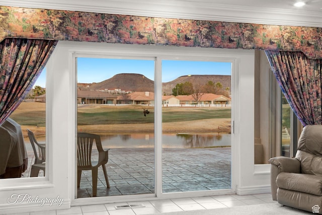 doorway featuring ornamental molding, tile patterned flooring, and a water and mountain view