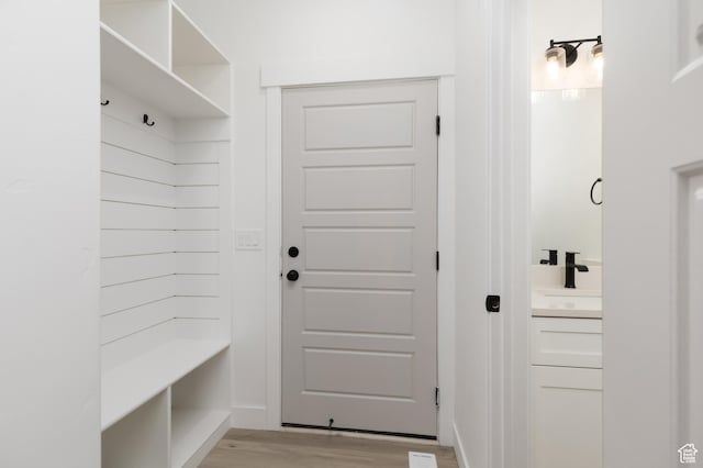 mudroom with light wood-type flooring and a sink