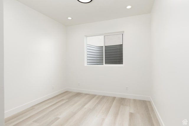 spare room featuring light wood finished floors, baseboards, and recessed lighting