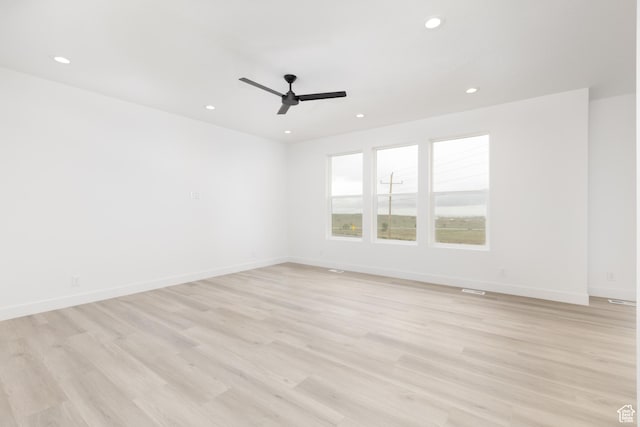 spare room featuring a ceiling fan, recessed lighting, light wood finished floors, and baseboards