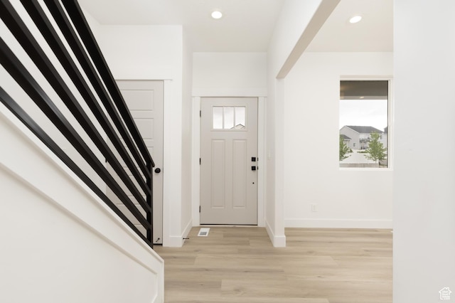 foyer entrance with light wood-type flooring, stairs, baseboards, and recessed lighting