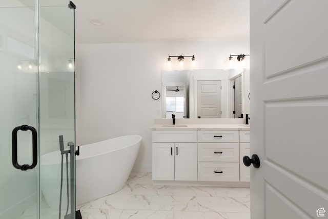 bathroom featuring a stall shower, marble finish floors, vanity, and a freestanding bath