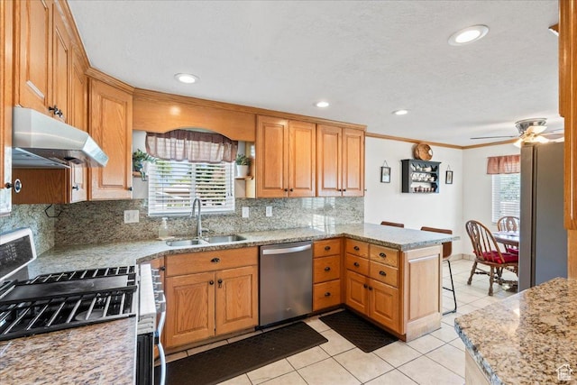 kitchen with stainless steel appliances, a sink, a peninsula, under cabinet range hood, and light tile patterned floors