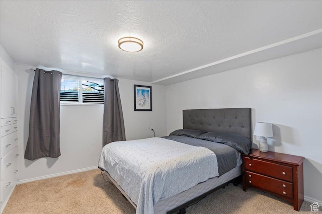 bedroom with light colored carpet, a textured ceiling, and baseboards
