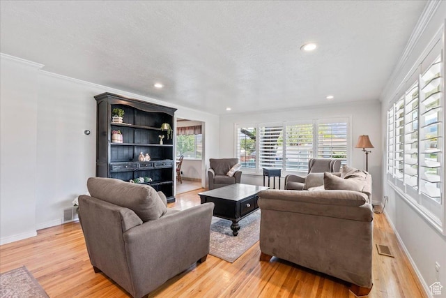 living area with light wood-style floors, ornamental molding, baseboards, and recessed lighting