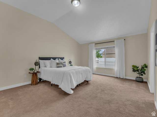 carpeted bedroom featuring lofted ceiling and baseboards
