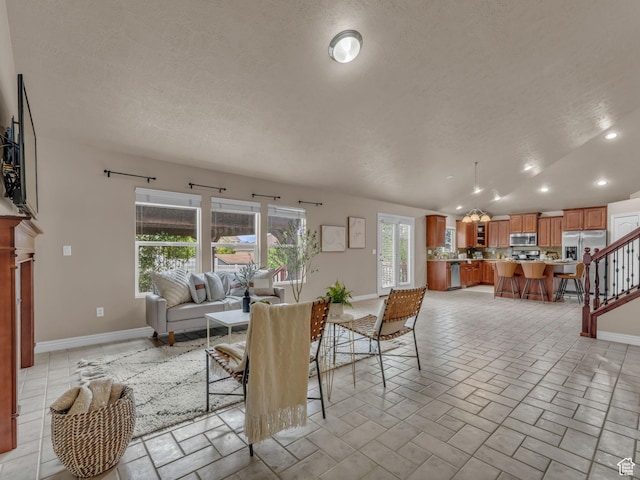 living room with a textured ceiling, baseboards, recessed lighting, and stairs