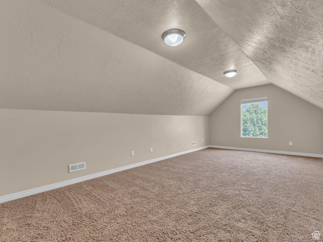 bonus room with a textured ceiling, baseboards, carpet flooring, and lofted ceiling