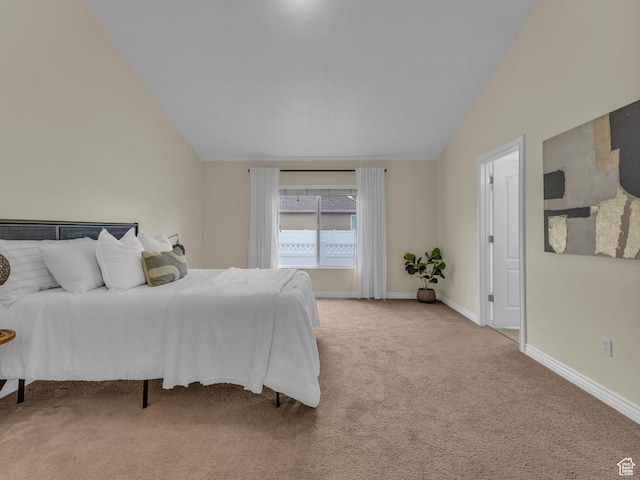 bedroom featuring lofted ceiling, light colored carpet, and baseboards