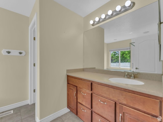 bathroom with tile patterned floors, vanity, and baseboards