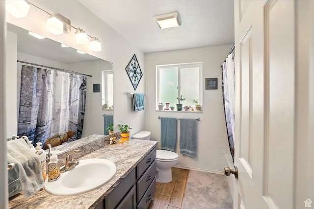 634 W 600 N, Brigham City, UT 84302 - bathroom with vanity, toilet, wood finished floors, a shower with shower curtain, and baseboards