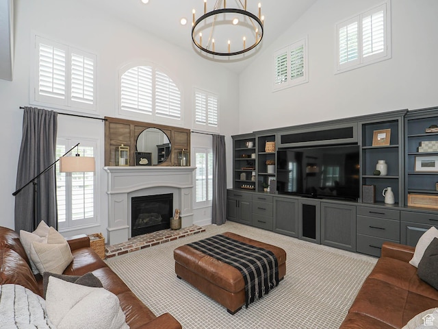 living area with high vaulted ceiling, a chandelier, plenty of natural light, and a fireplace