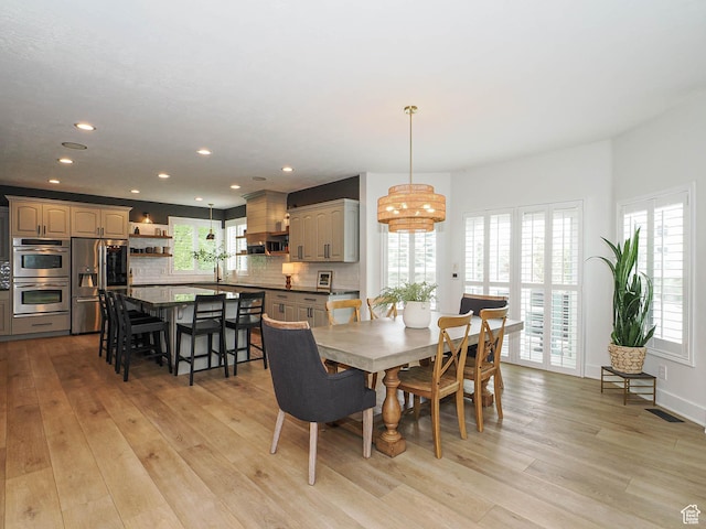 dining space with light wood-style flooring, recessed lighting, and a chandelier