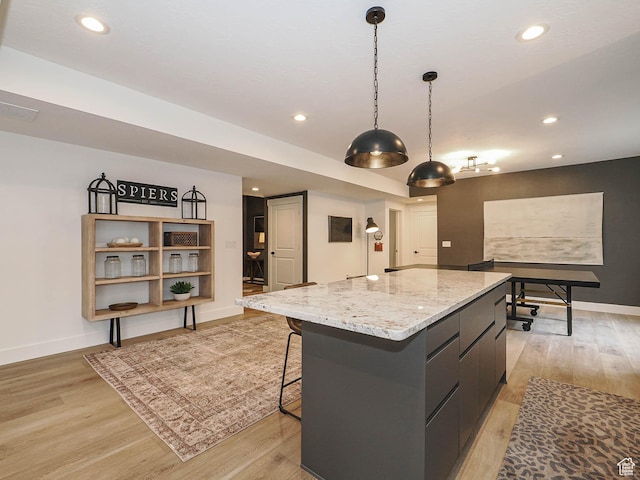 kitchen with a kitchen island, light wood-type flooring, baseboards, recessed lighting, and pendant lighting