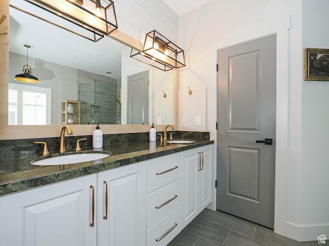 bathroom featuring a stall shower, double vanity, and tile patterned floors
