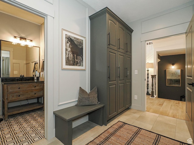 mudroom featuring a sink and light tile patterned floors