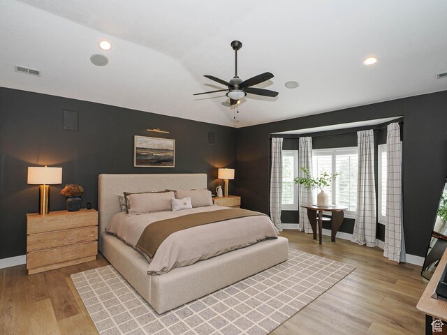 bedroom with baseboards, vaulted ceiling, light wood-type flooring, a ceiling fan, and recessed lighting