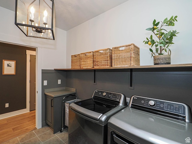 laundry area featuring independent washer and dryer, a chandelier, tile patterned floors, and baseboards