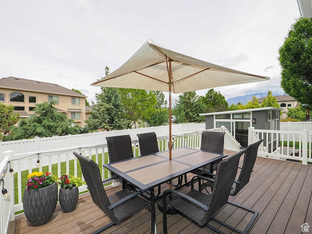 wooden terrace with outdoor dining area and fence