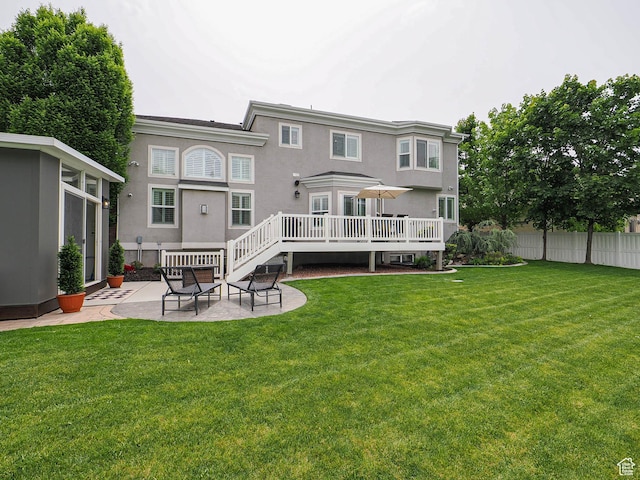 rear view of house with a patio, stucco siding, and a wooden deck