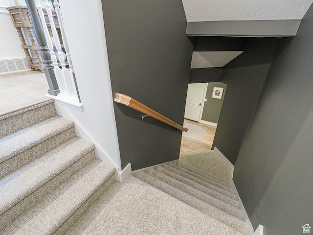 stairs featuring wood finished floors and baseboards