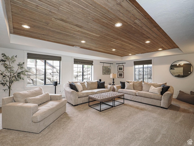living room featuring a raised ceiling, wooden ceiling, recessed lighting, carpet, and healthy amount of natural light