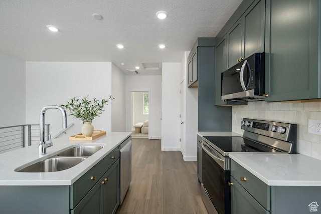 441 N Bishop Pl Unit 4-17, Salt Lake City, UT 84103 - kitchen featuring stainless steel appliances, a sink, dark wood-style flooring, tasteful backsplash, and light countertops