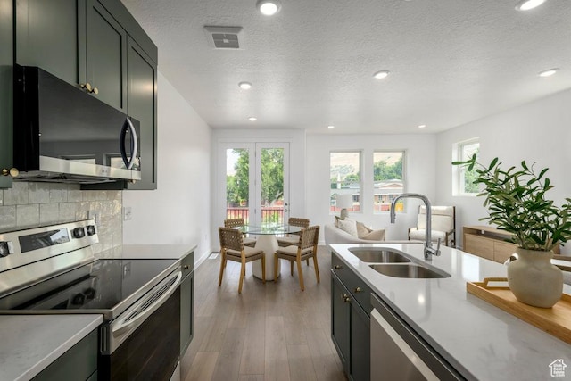 441 N Bishop Pl Unit 4-17, Salt Lake City, UT 84103 - kitchen with stainless steel appliances, a sink, wood finished floors, recessed lighting, and backsplash