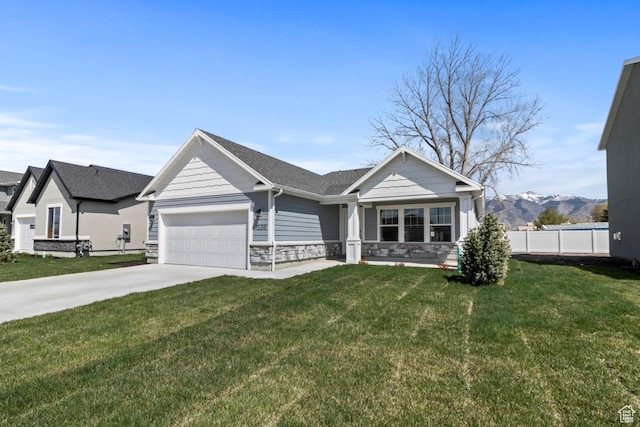 view of front of property featuring an attached garage, concrete driveway, stone siding, a mountain view, and roof with shingles