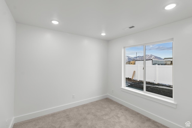empty room with light colored carpet, baseboards, and recessed lighting